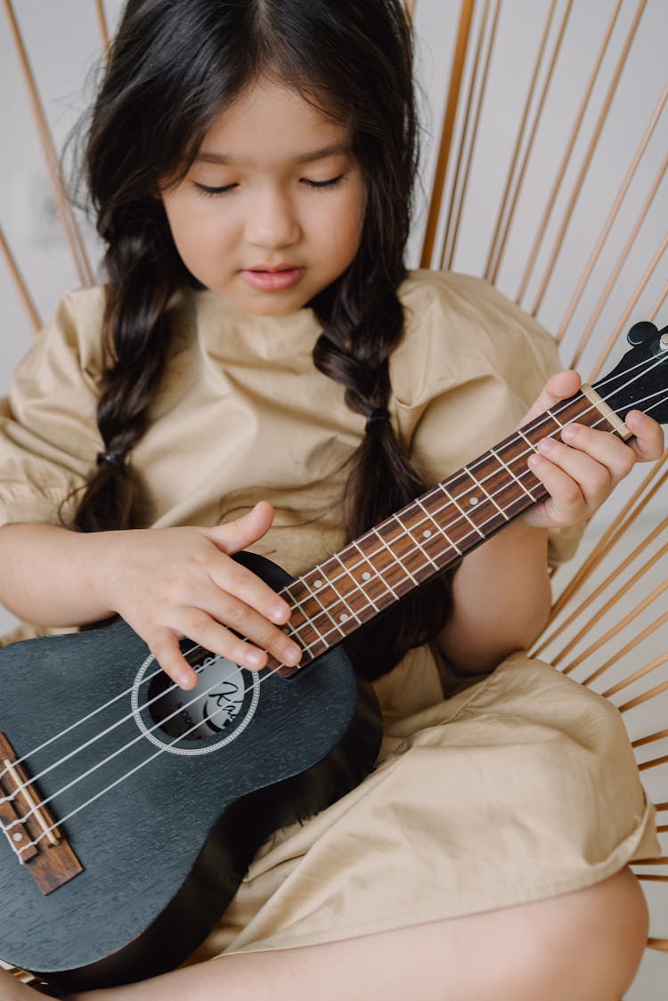 A Cute Girl Playing Ukulele