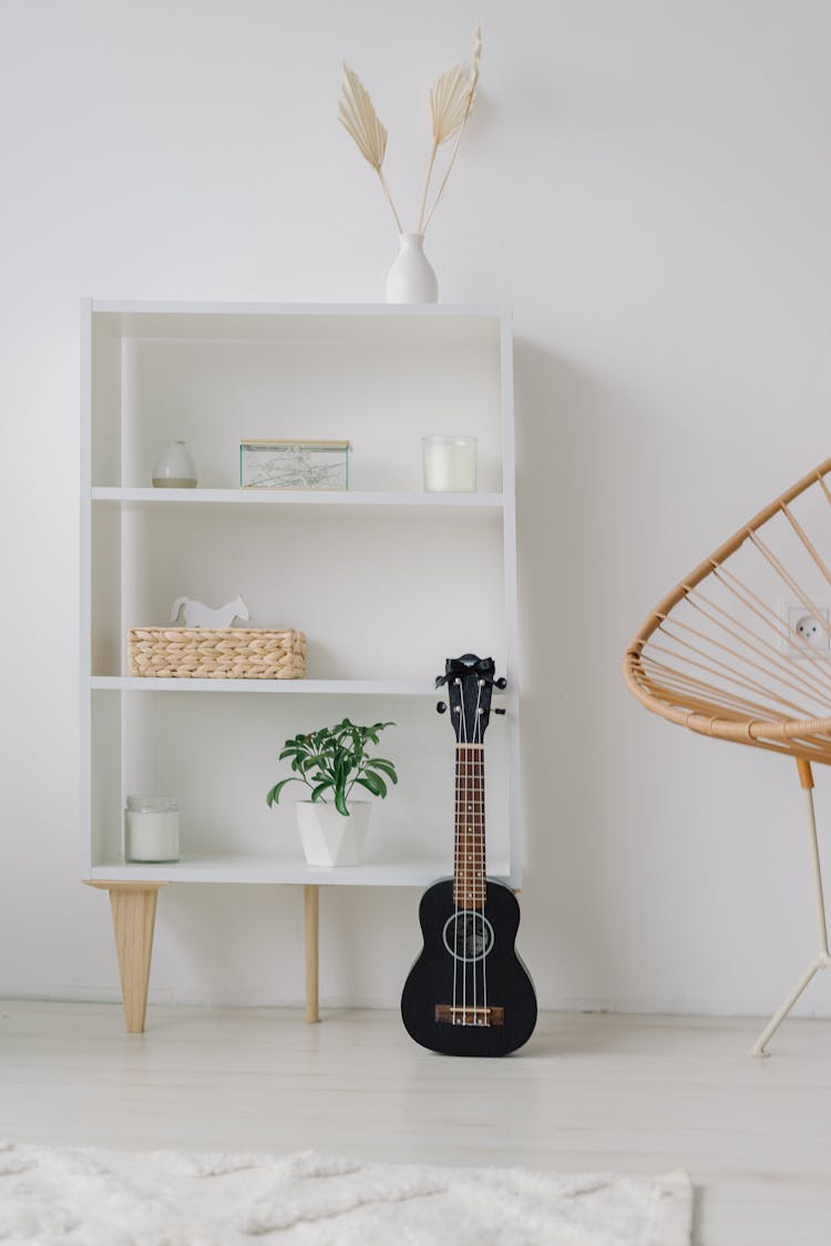 White Bookcase With Decorations Near White Wall