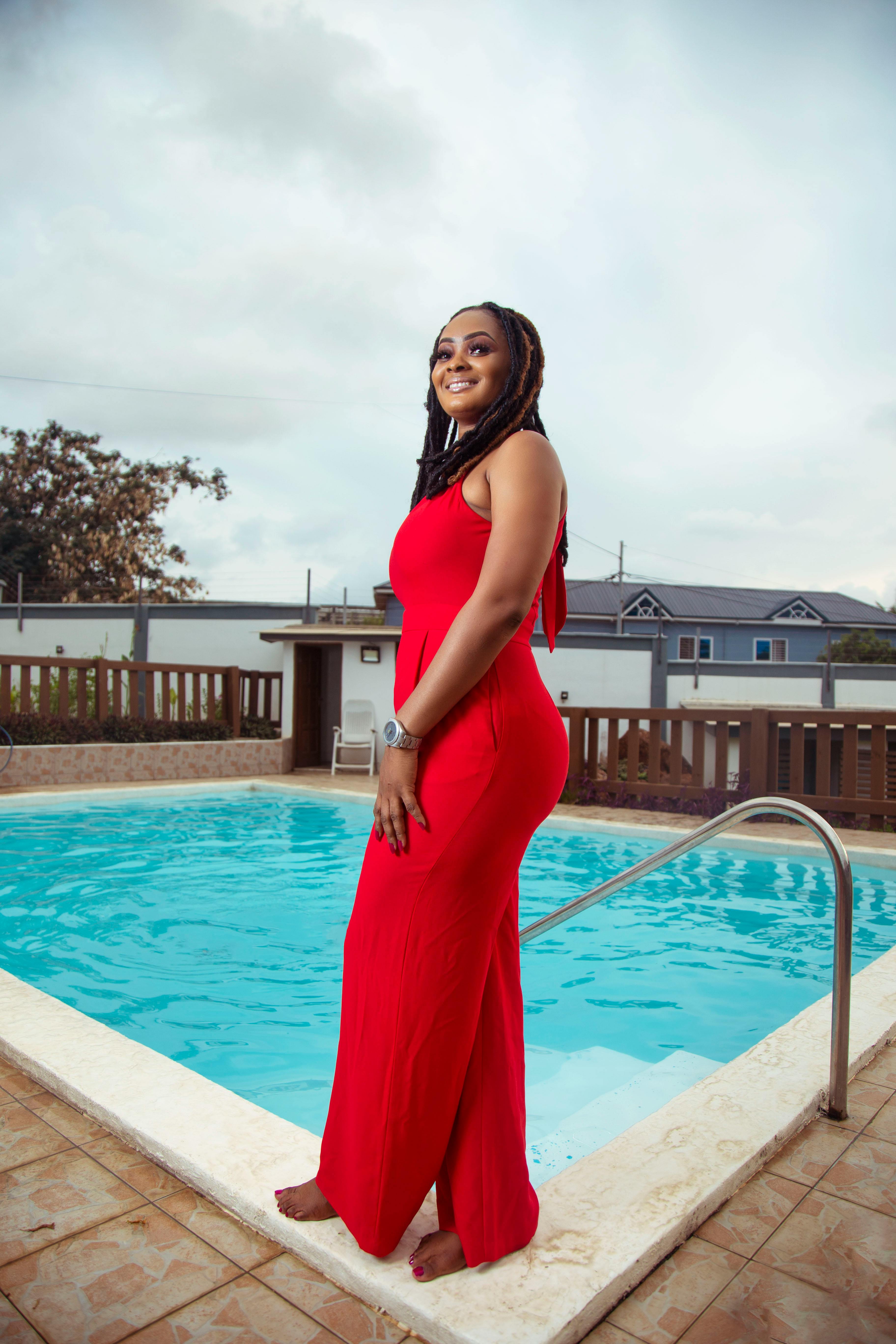 Woman in a Red Sleeveless Dress Standing beside a Swimming Pool  Free  Stock Photo