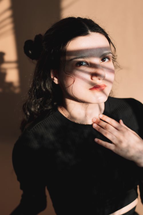 Free Artistic portrait of a woman in shadow, expressing introspection and emotion. Stock Photo
