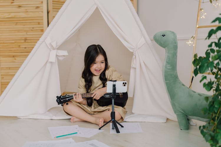 A Cute Girl Recording A Video While Playing Ukulele