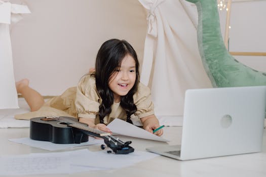 Adorable child engaging in online learning with a ukulele and laptop indoors.