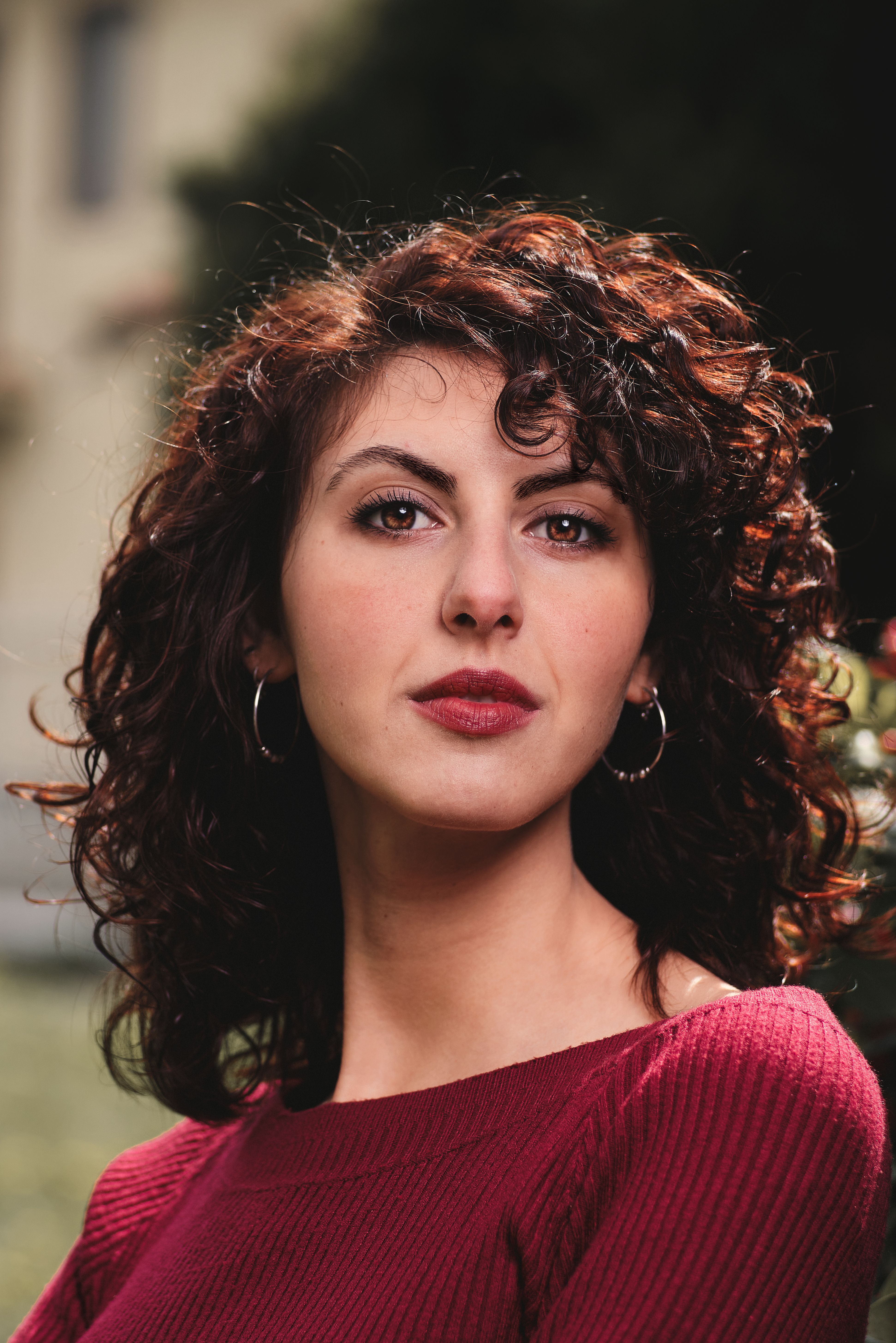 Elegant portrait of a woman with curly hair in Turin, capturing a confident expression and poised look.