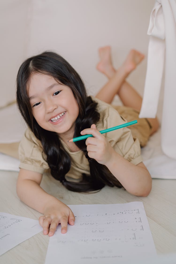 A Girl Holding A Green Pencil