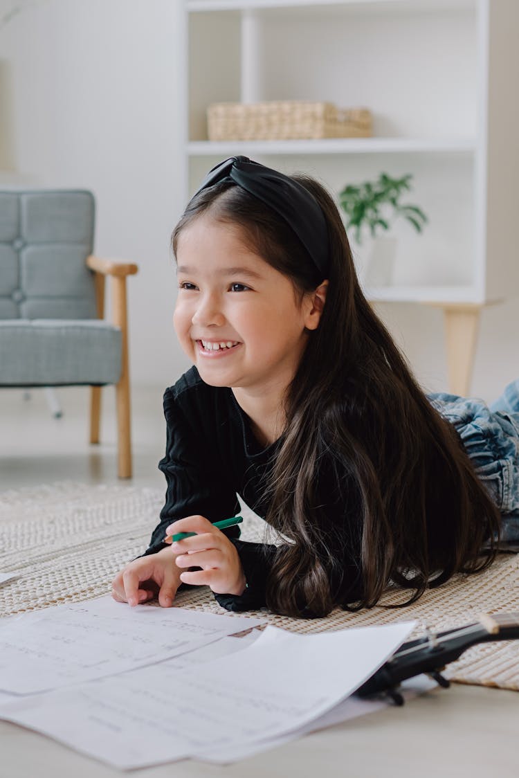 A Girl Doing Her Homework On The Floor