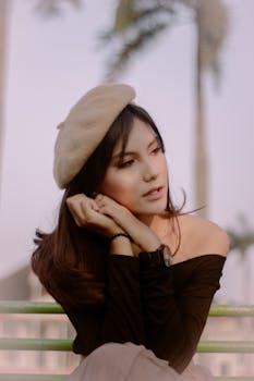 Elegant woman in a beret posing outdoors in Bengkulu, Indonesia. Soft and warm tones.