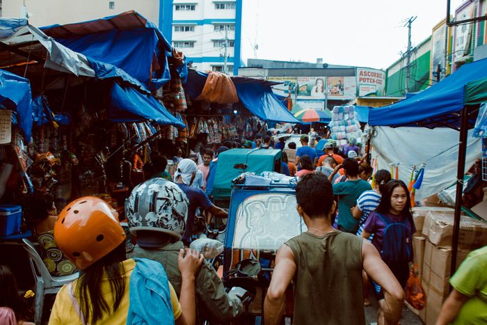 Shoppers walking through a busy market street