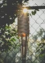 Wooden Torch Near the Metal Fence
