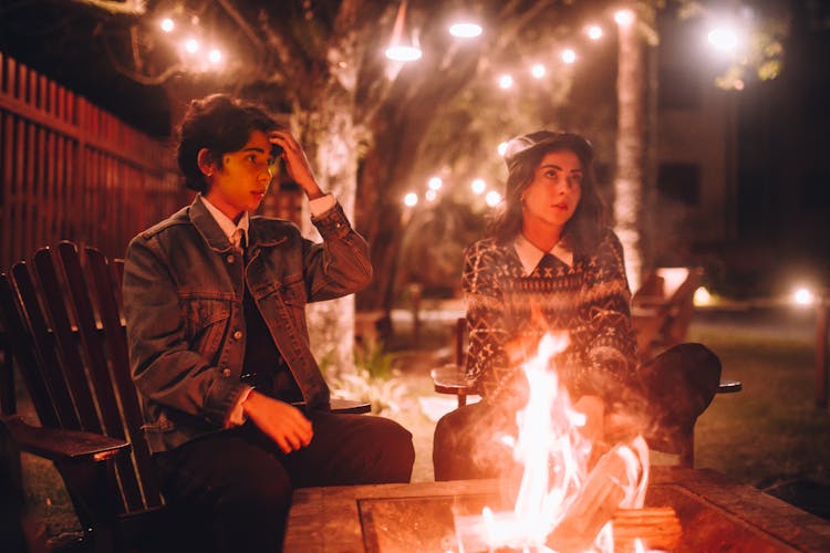 Man And Woman Sitting By The Fire Pit