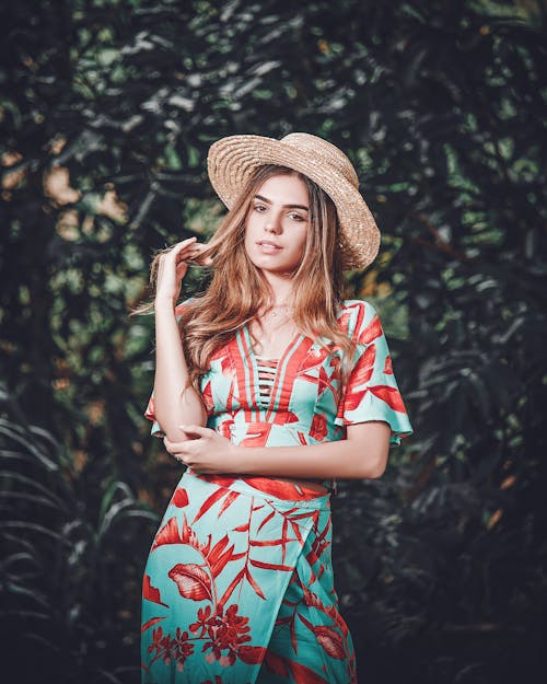 Woman in a Dress Holding a Straw Hat · Free Stock Photo