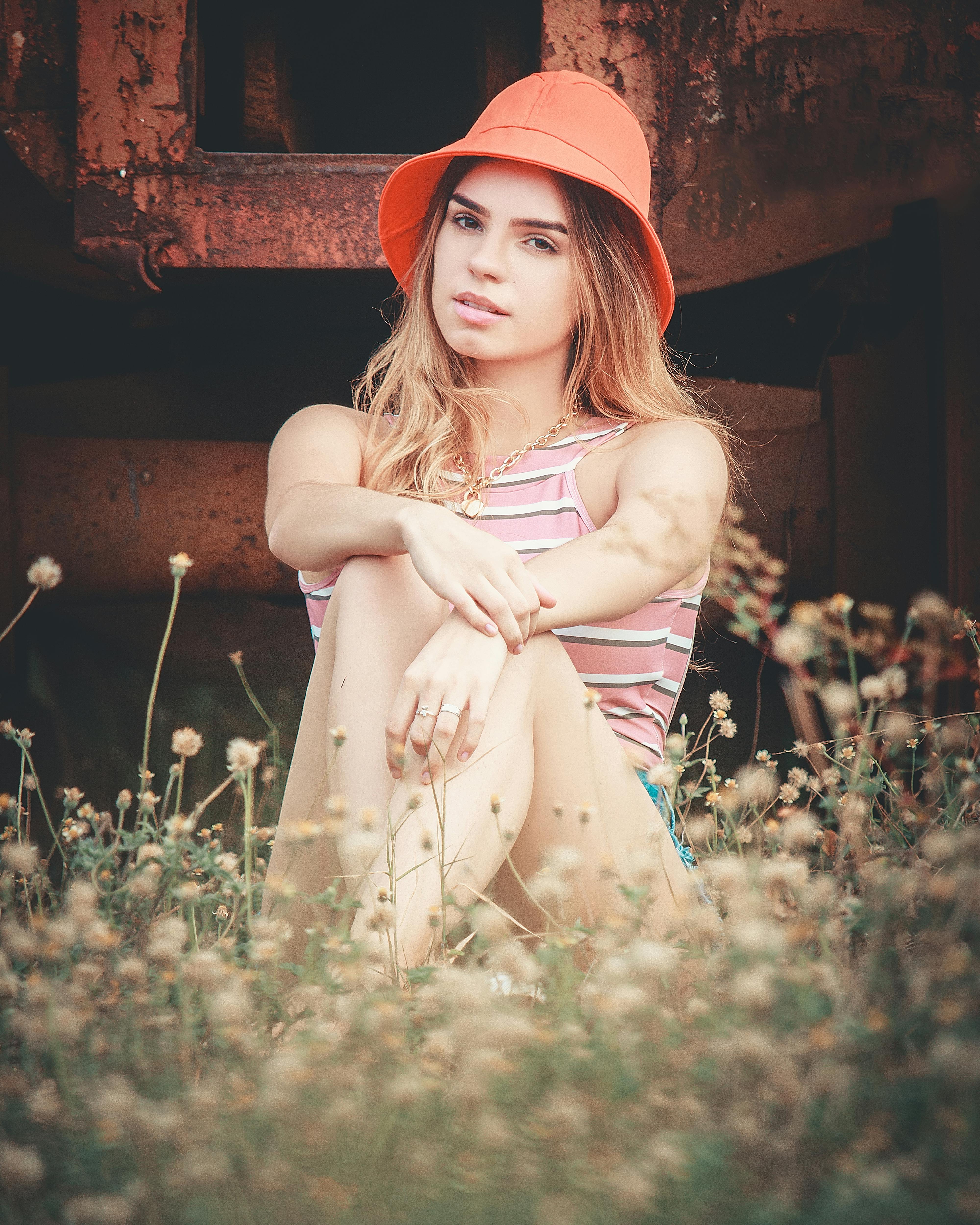 a woman sitting on the ground with wildflowers