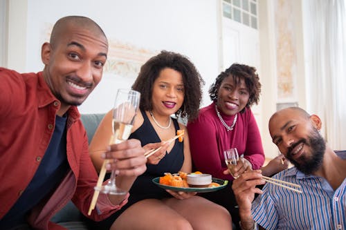 Men and Women Eating and Drinking While on the Couch