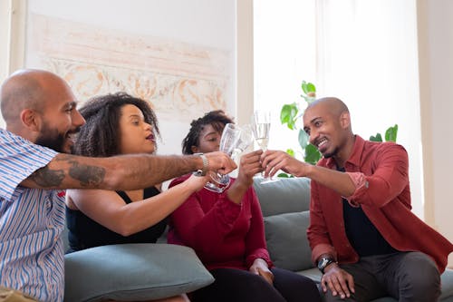 Free People on the Couch Holding Wine Glasses Stock Photo