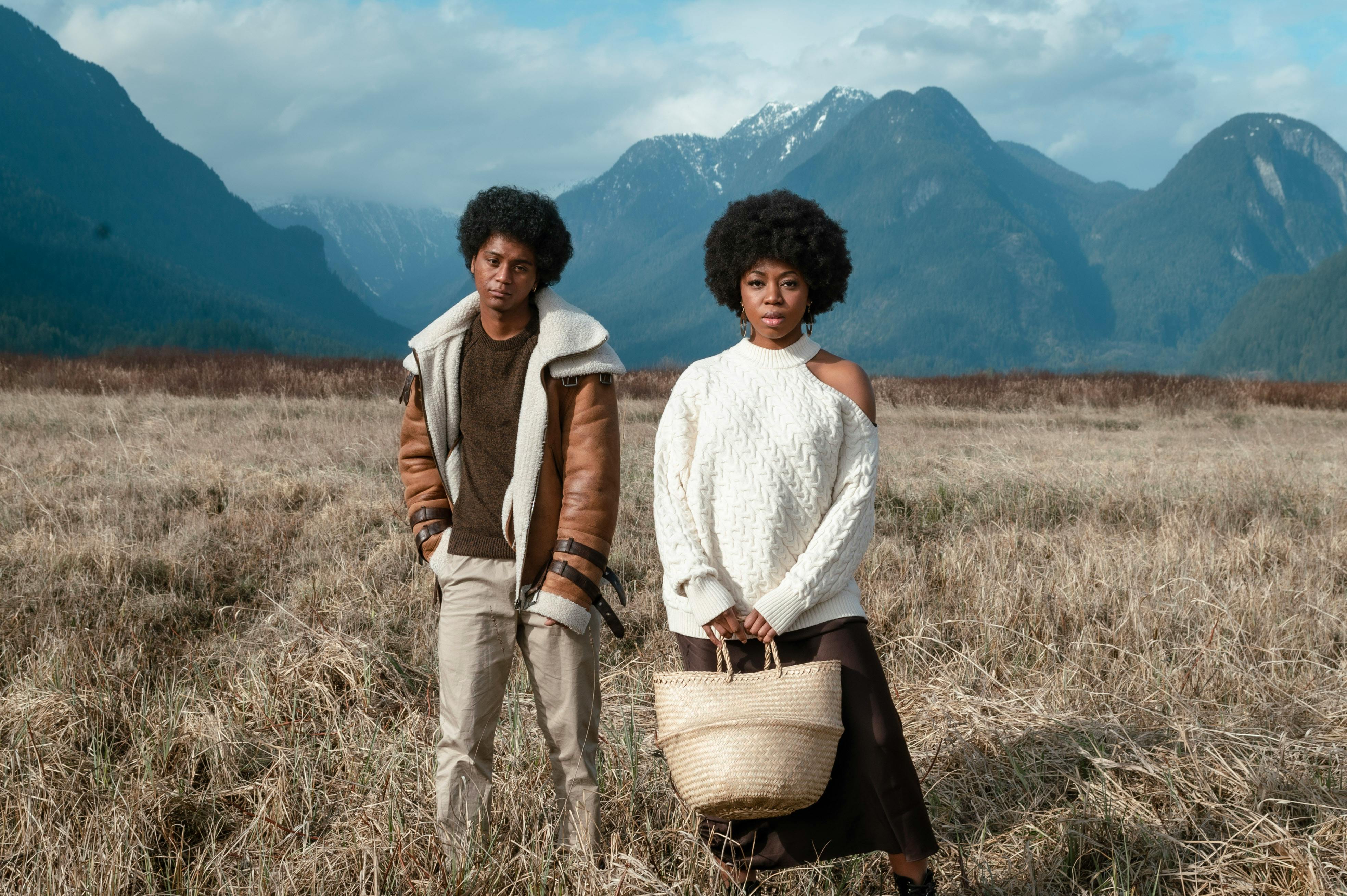 a man and a woman standing on a grass field