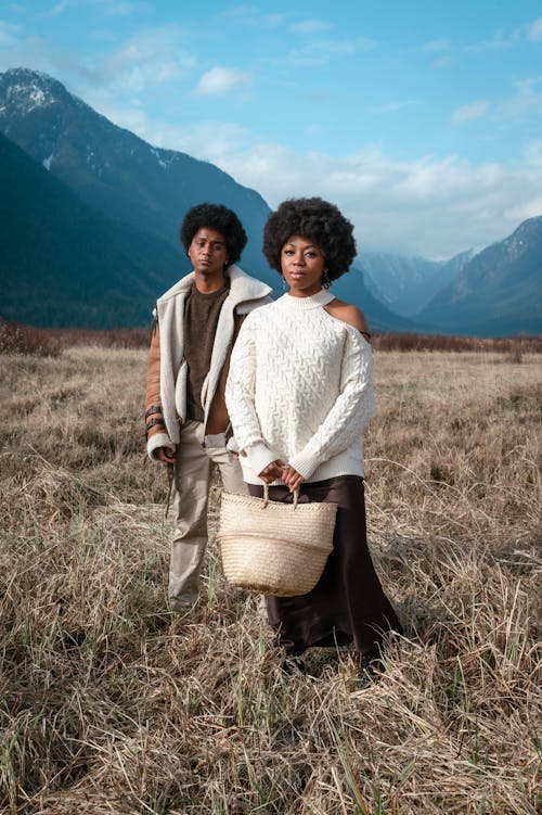 A Fashionable Woman and a Man Standing on Grass Field