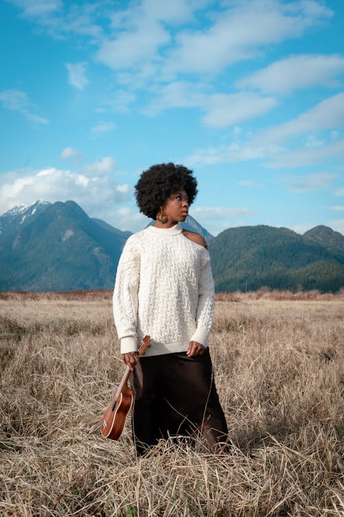 Woman in White Long Sleeve Shirt and Black Skirt Standing on Brown Grass Field