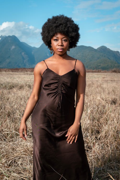 Photo of a Beautiful Woman in a Black Dress with an Afro Hairstyle