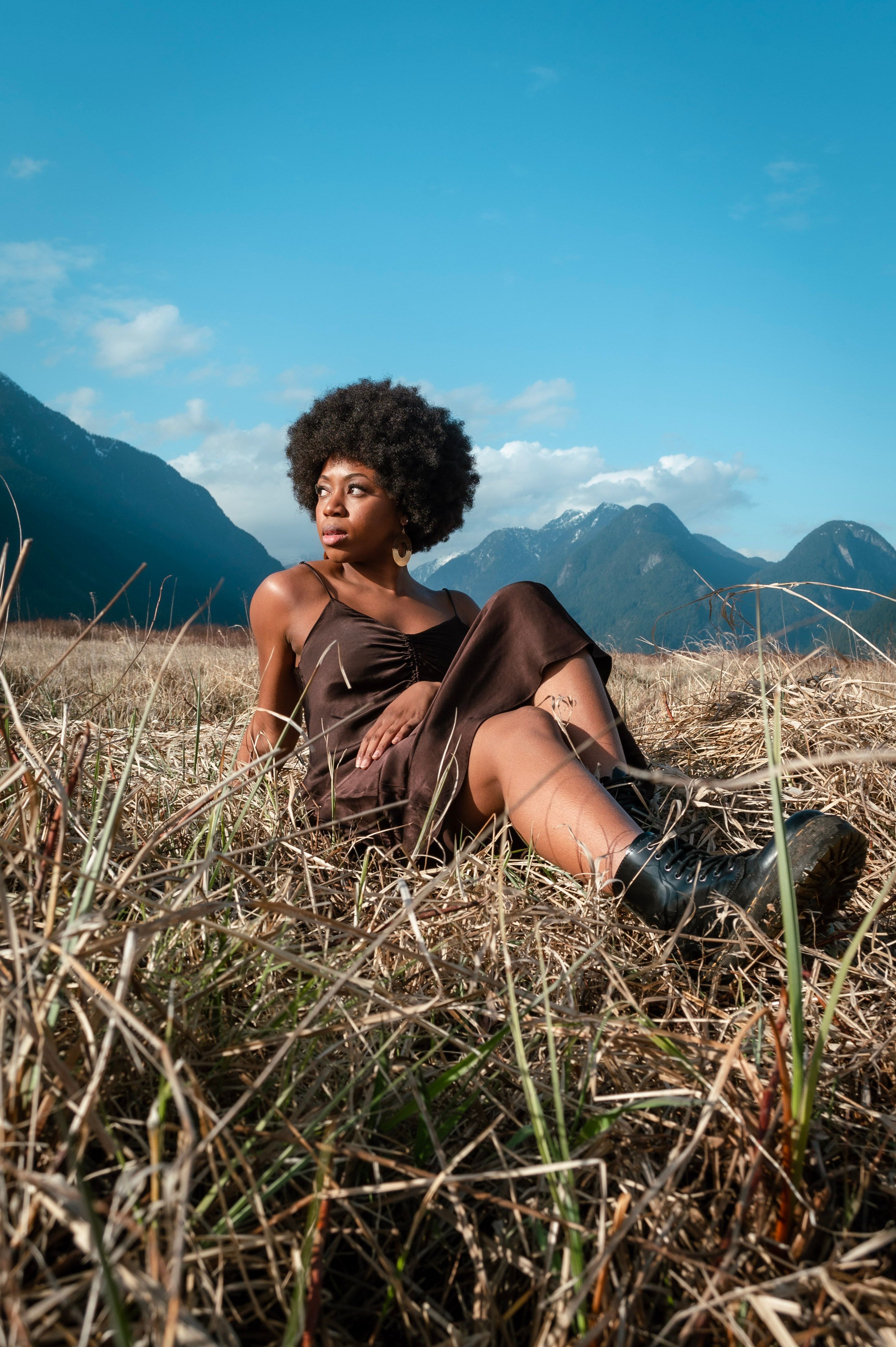 Woman in a Dress Sitting on Brown Grass Field · Free Stock Photo