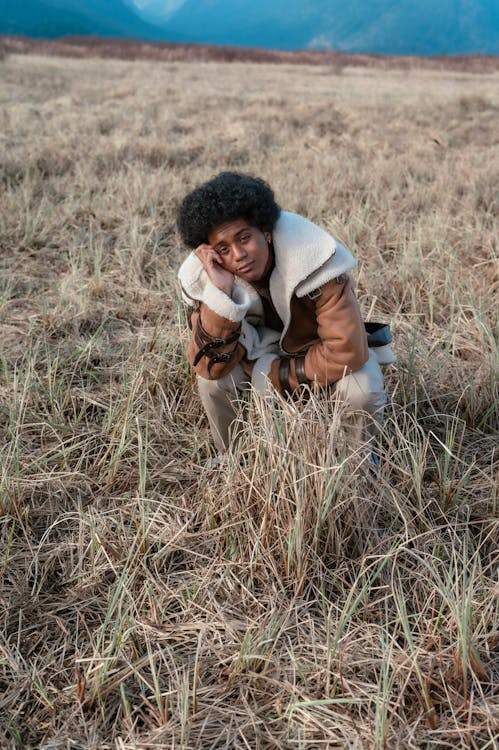 Man Sitting on Brown Grass Field