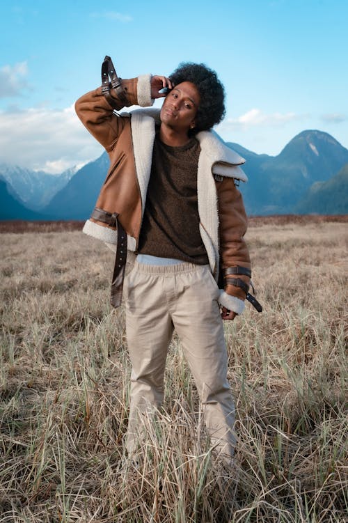 Man in Brown Jacket and Pants Standing on Brown Grass Field