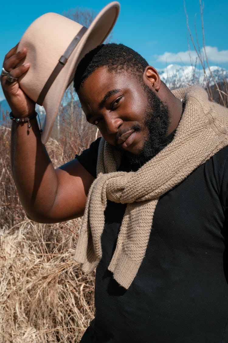 Close-Up Photo Of A Handsome Man Taking Off His Beige Hat