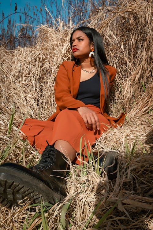 A Woman Posing while Sitting in a Field