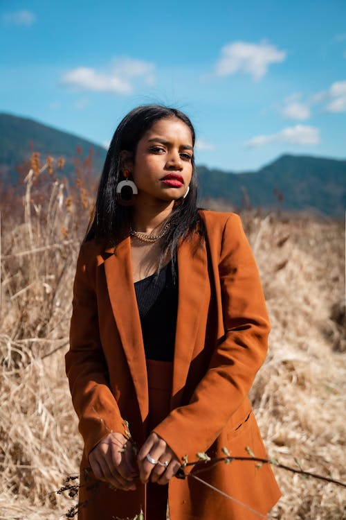 Woman in Brown Coat Standing on Brown Field