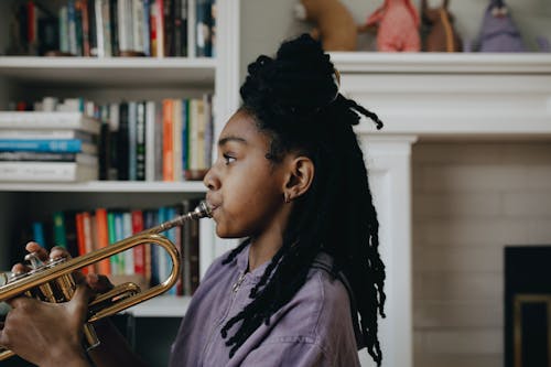 Woman in Purple Shirt Playing the Trumpet