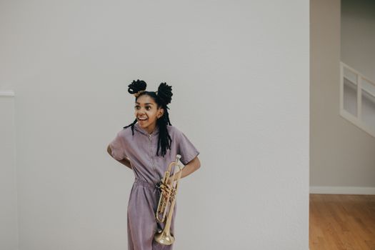 A Woman Standing Holding a Trumpet