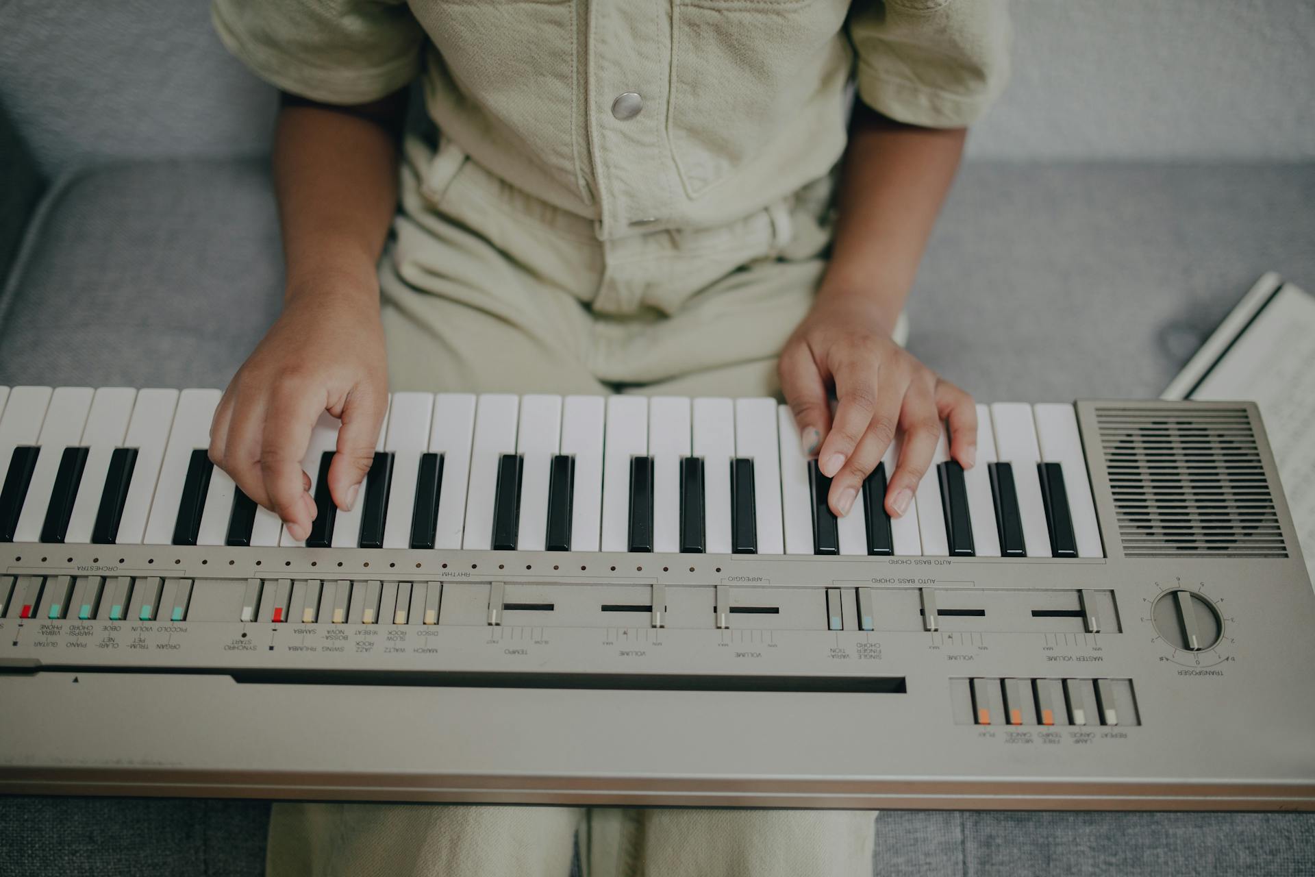 A child practicing music on an electric keyboard, showcasing young talent and creativity.