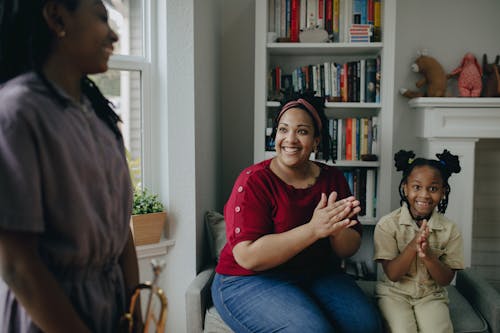 Free A Woman and a Child Clapping in a Living Room Stock Photo