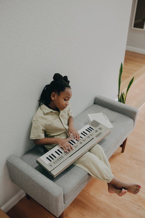 A Girl Playing an Electronic Keyboard at Home
