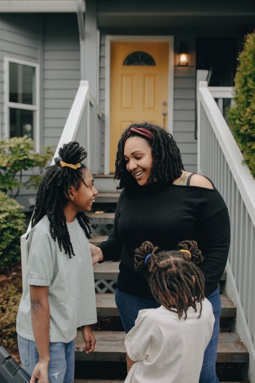 Free A mother and her daughters enjoying a cheerful moment together outdoors. Stock Photo