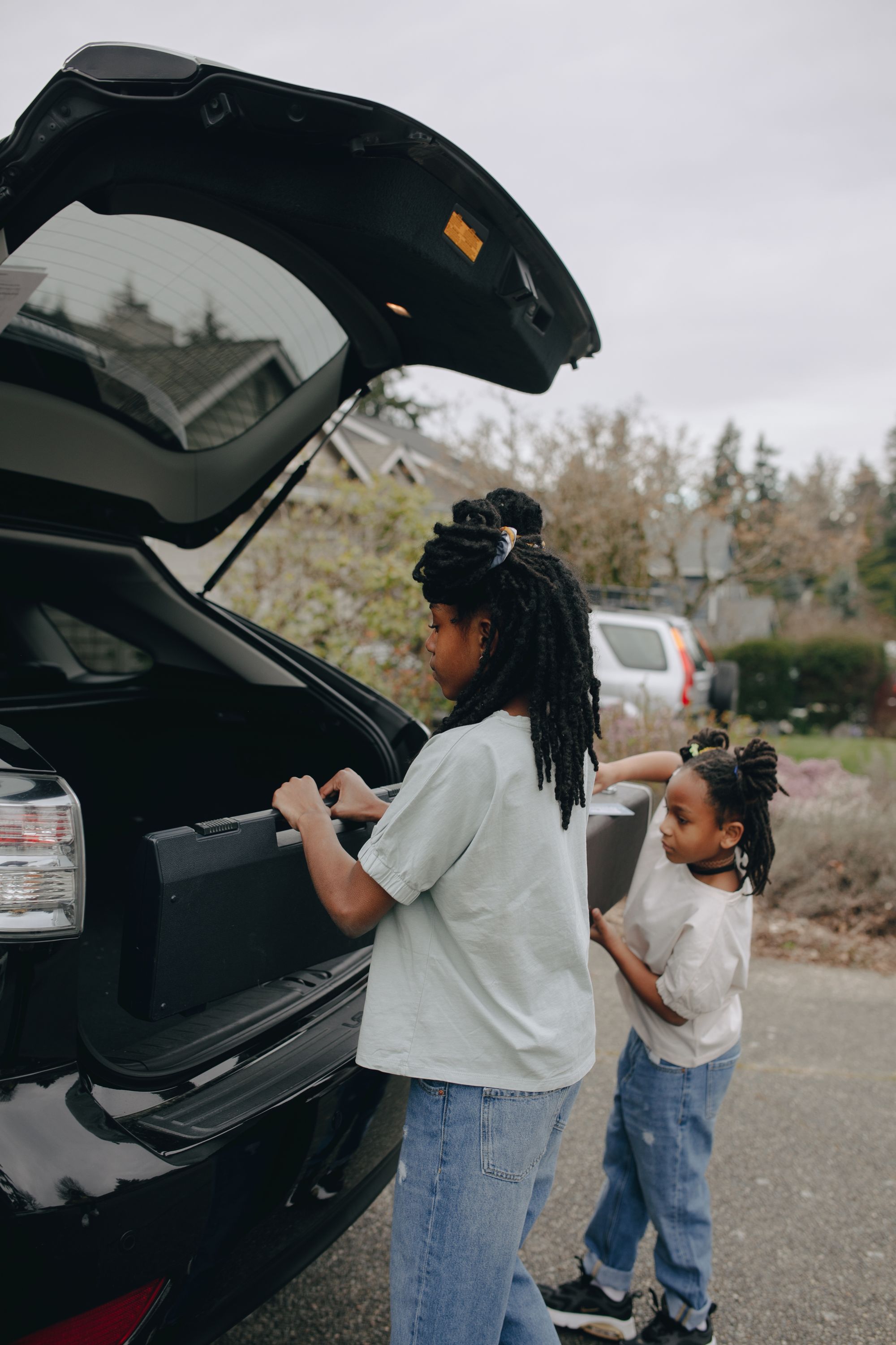 Travel luggage being loaded into the trunk of a real vehicle