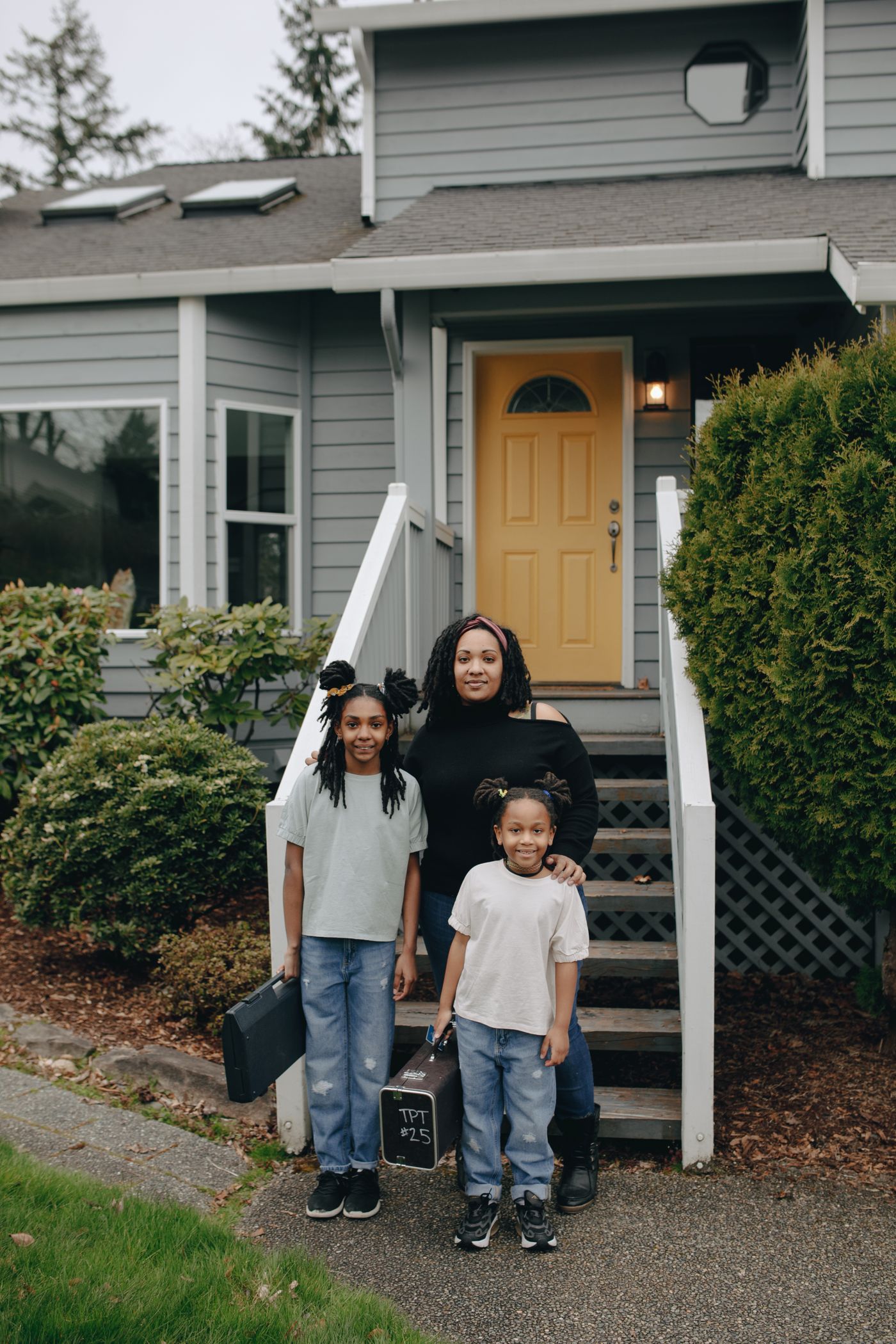 Family standing together in front of their home