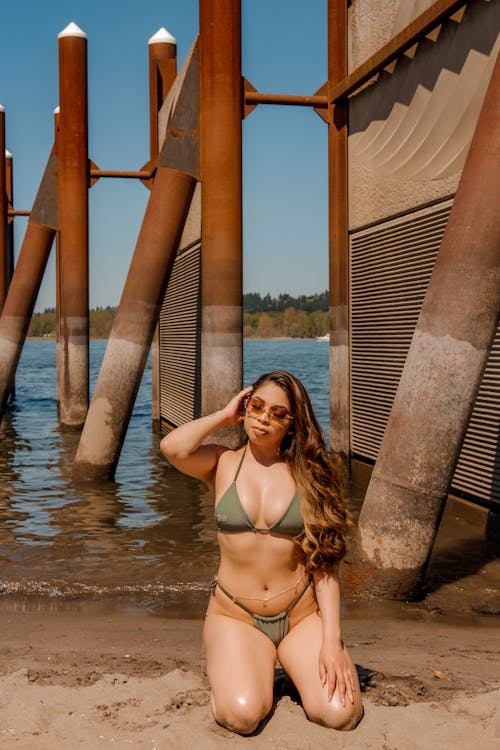 Free A Sexy Woman Wearing a Bikini while Leaning on the Sand Stock Photo