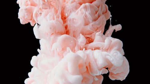 Free Captivating abstract image of pink ink swirling in water against a black background. Stock Photo
