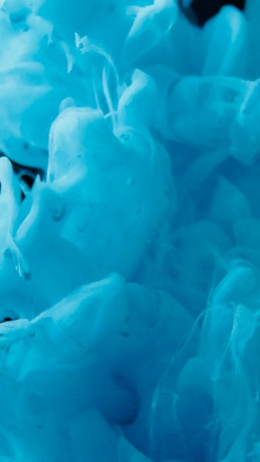 Fotomural Explosión dinámica de tinta azul vívida en agua, mostrando patrones fluidos abstractos.