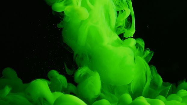 Abstract green ink cloud swirling in dark liquid showcasing vibrant movement and mystery.