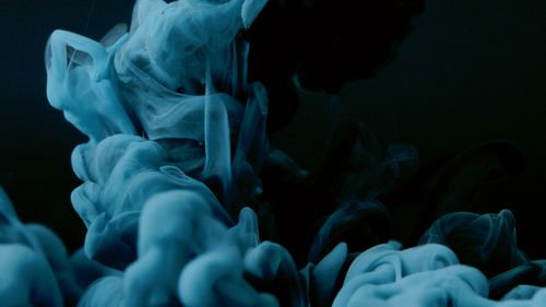 Free Close-up of abstract blue ink swirling in dark water, creating a mesmerizing pattern. Stock Photo
