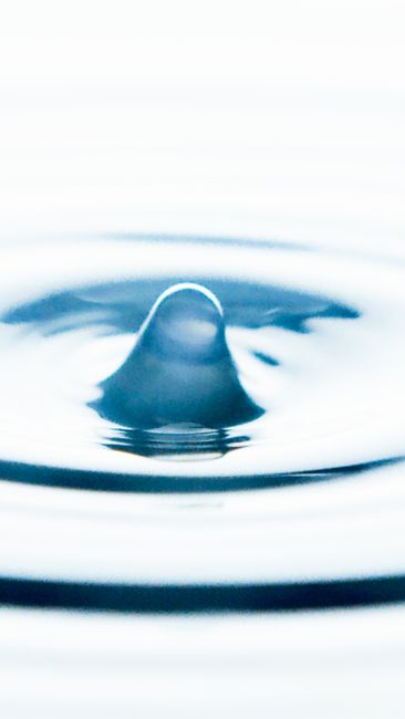 Fotomural Imagen macro de alta resolución de una gota de agua creando un efecto de onda en agua clara.