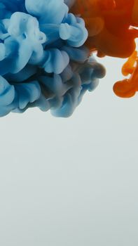 Abstract art featuring dynamic blue and orange ink mixes underwater, creating fluid motion.