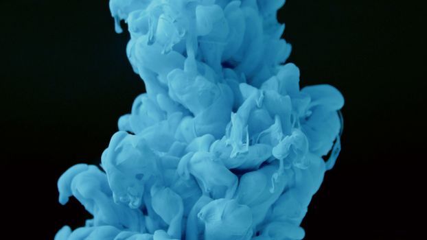 Vivid blue ink swirls creating an abstract pattern underwater against a dark backdrop.