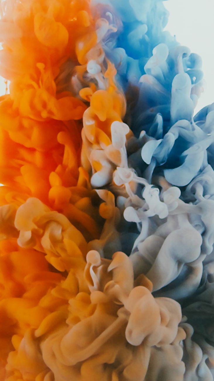 Vibrant abstract color burst artwork with orange and blue swirling smoke effect.