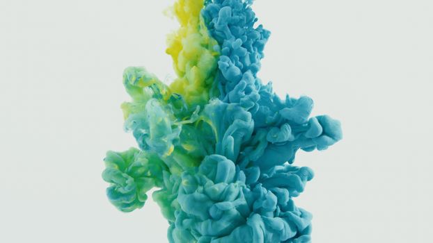 Dynamic swirl of blue and yellow ink in water, creating a vibrant abstract pattern.