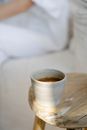 Woman sitting on sofa with cup of tea