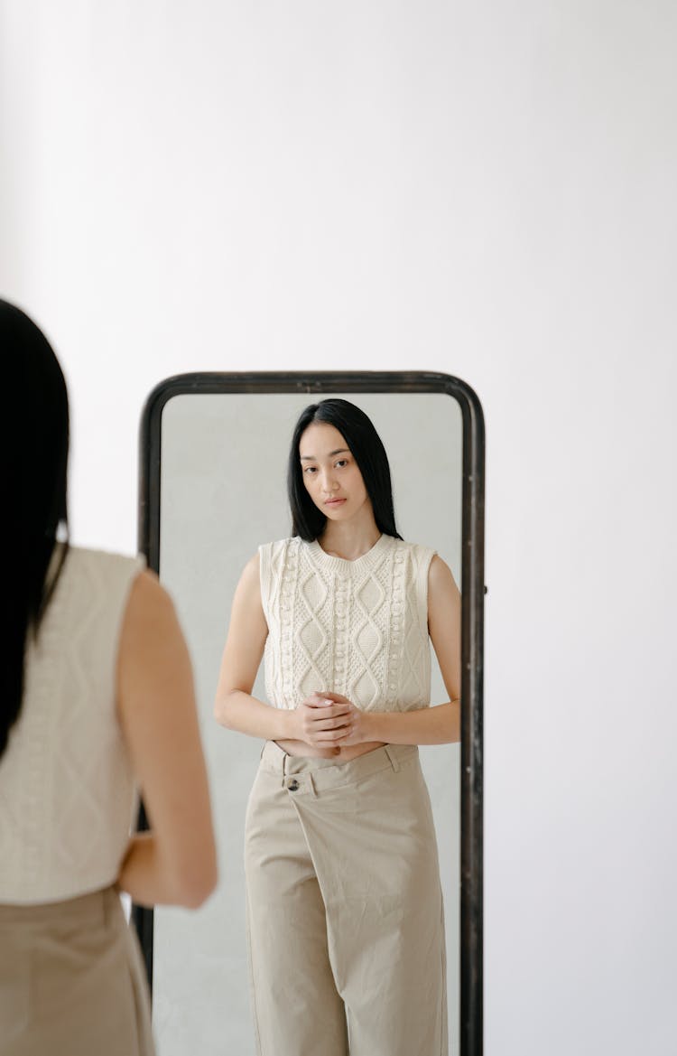 Serious Ethnic Woman Standing Near Mirror