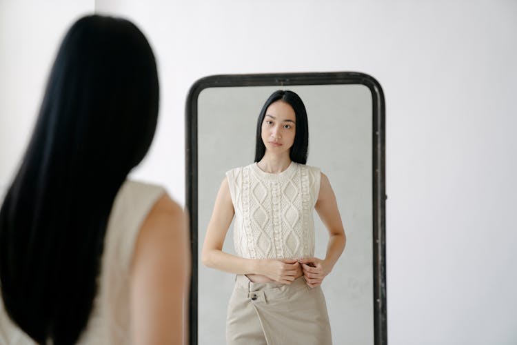 Young Ethnic Woman Looking At Mirror