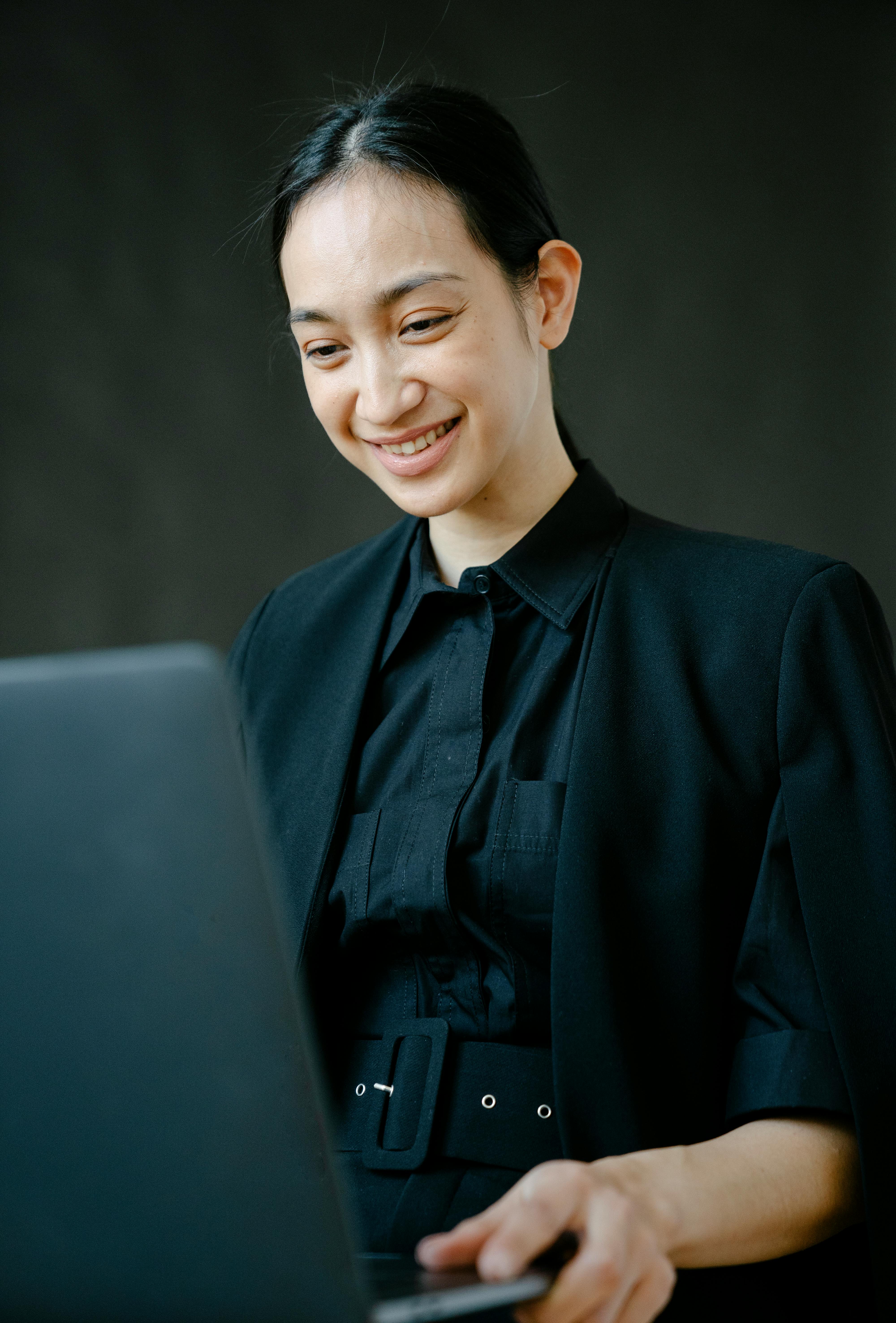 smiling asian businesswoman working on laptop