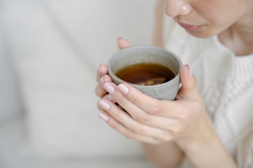 Free Woman Holding a Ceramic Cup with Tea Stock Photo